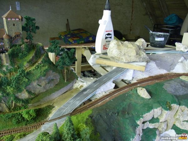 Beim Bahnübergang ist die Strasse schon befestigt. Sie schliesst sich praktisch ohne Lücke an das Gleis an.
