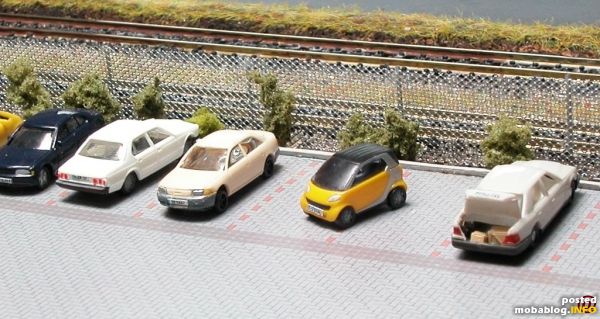 Bearbeitete Fahrzeuge auf dem Parkplatz meiner Modulanalage; ganz rechts steht ein Mercedes, bei dem ich den Kofferraum "geöffnet" habe (mit einem Skalpell abgetrennt und geöffnet angeklebt) - im geöffneten Kofferraum ...