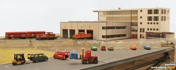 Das Hafenhaus mit Parkplätzen. Zwischen den Zäunen laufen zwei Gleisanschlüsse.