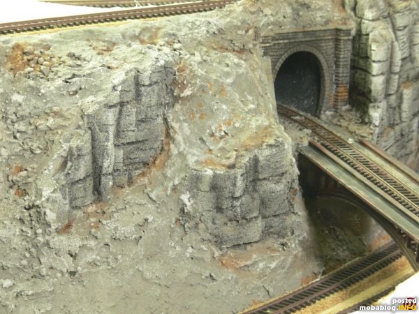 Der Blick durch die alte Steinbogenbrücke, entlang der Strasse auf das vorerst fertig gestellte Teilstück. Wie schon vorher angesprochen soll in den jetzt noch braunen Ecken und Nischen grüne Vegetation ...