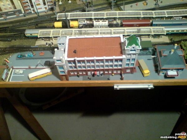 Die Gesamtansicht.
Links die Zufahrt zum Bahnhof und der Hof zur Beschickung des Bahnsteiges.
Der Parkplatz ist aus Papieraufklebern passend zurechtgeschnitten worden.
Rechts der Posthof mit Verwaltungsgebäude. Mittlerweile hat es hier mehr Fahrzeuge, ...