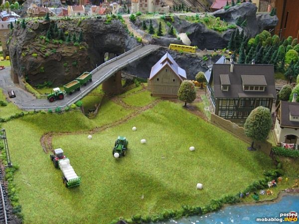 Reger Betrieb beim Bauern mit Kornabtransport auf der Bergstrasse und Verladen der gepressten Rundballen