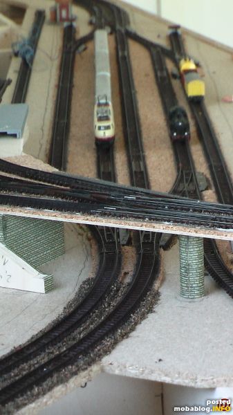 Probefahrten im unteren Hauptbahnhofsbereich mit 1970er Arnold-Material
Durch den runden Pfeiler werden die Kabel von den elektrischen Weichenantrieben geführt. Der Pfeiler besteht aus einem Alurohr, beklebt mit Faller-Mauerkarton. Der wird später ...