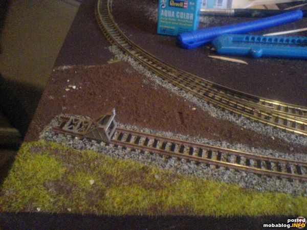In feuchter Abtönfarbe "Torfbraun" habe ich feinen Vogelsand hineingeriselt und mit einem Borstenpinsel Strucktur hinein getupft. In diese noch feuchte Erde habe ich mit der Streugrasdose das erste Grün hinein ...