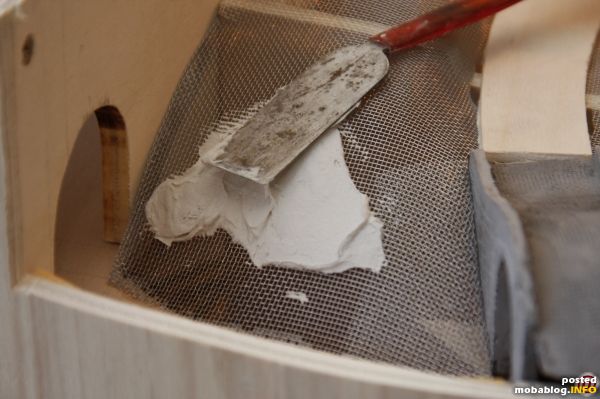 Das Fliegengitter wird mit Spachtelmasse bestrichen. Es wird dabei einiges an Masse benötigt. Ich habe "Innenspachtel" aus dem Baumarkt verwendet, der sich einige Zeit lang verarbeiten lässt. Einfacher Gips bindet ...