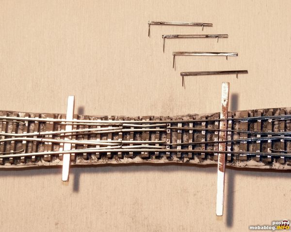 eine Seite sind die Zungen schon eingebaut, andere Seite sind die Zungengelenke und die Bohrungen in den Schwellen zu sehen. ich hab 0,3mm Federstahldraht angelötet.