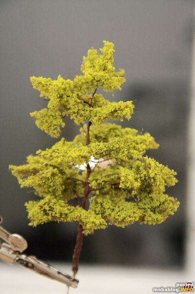Am Schluss wird der fertige Baum (am besten mit anderen gemeinsam) mit mattem Sprühkleber übersprüht, damit die einzelnen Flocken des „Flors“ fixiert werden und die Blätterimitation an Stabilität gewinnt.