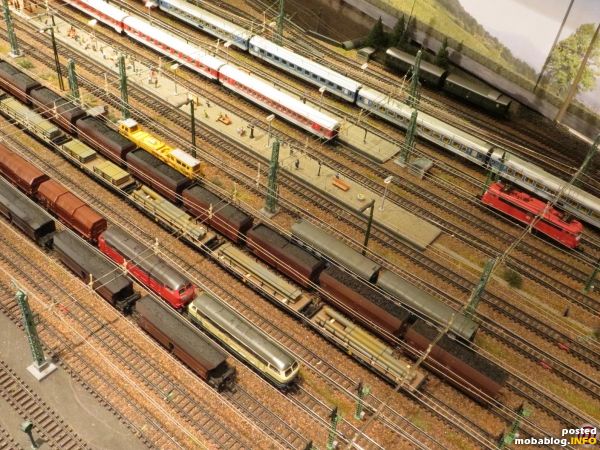Blick auf die Osteinfahrt des Bahnhofs mit IR, IC und einer parkenden Bügelfalten-110. Vorne unten eine 216-Doppeltraktion vor schwerem Coilzug.