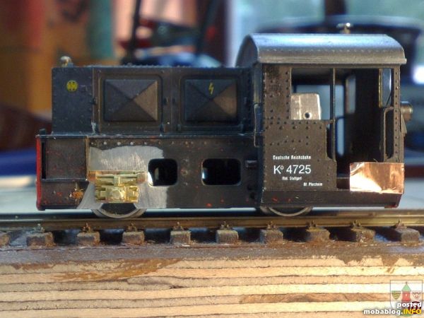 Hier sind nun alle alten Bauteile sorgfältig abgetragen und das Messinggußbauteil zur Probe am Außenrahmen angeheftet.
Dieses muß nun noch ein wenig bearbeitet und versäubert werden, mit Niete gemäß Vorbild ausgerüßtet ...