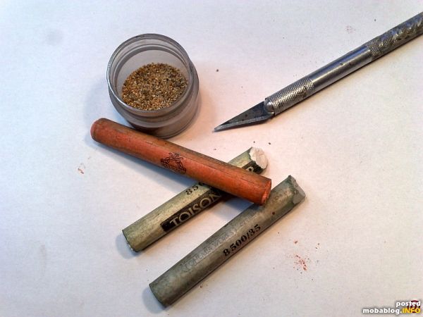 Die Hilfsmittel zum färben, feinste Künstlerpastellkreiden und maßstäblicher mineralischer Schotter in einem Schraubglas.
Von den Pastellkreiden werden sehr fein Pigmente abgeschabt, in das Glas dem Schotter zugegeben, Deckel drauf und lange ...