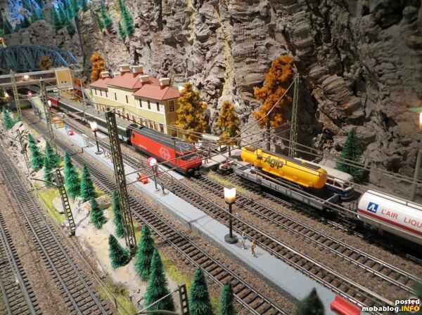 Eine Re 460 hat den Tunnel hinter sich gebracht und hält am Bahnhof