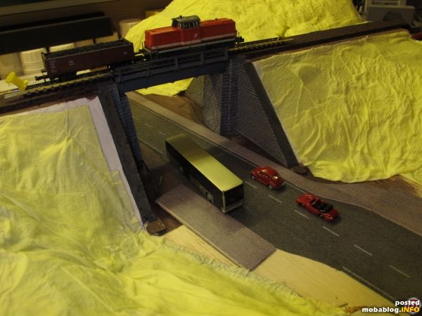 Auch die Bahntrasse ist bereits nivelliert, die Korkbettung ist fest verleimt und grundiert, einzig das Gleis liegt provisorisch. Sobald das Toilettenpapier durchgetrocknet ist, kann eine erste Schicht Moltofill aufgebracht werden.