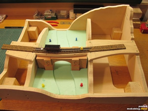 Als nächstes wird hier das Flussbett aus dem Styrodur herausgeschnitten und entsprechend ausgestaltet, bevor es mit Faller-Naturwasser geflutet wird. Der Modulanschluss rechts passt zum Anschluss der Modulkomposition "Weitenegg" an der ...
