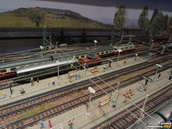 An ähnlicher Stelle rangiert eine Ee 3/3 (Arnold) einen Leichtstahlpackwagen (Arnold), ein Gleis dahinter fährt soeben die TEE-Re 4/4
