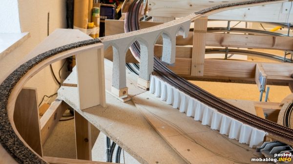 Die Nebenstrecke überquert die Hauptstrecke und einen zukünftigen Fluss. Das Viadukt ist noch im Rohbau und mit HekiDur Mauerplatten bestückt.