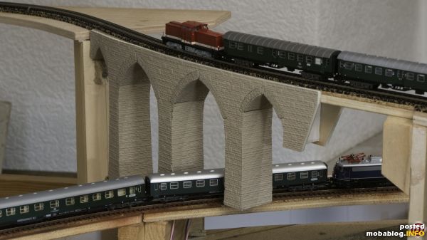 Unter der Brücke fährt eine E 10.3 Bügelfalte von Fleischmann mit Schnellzugwagen