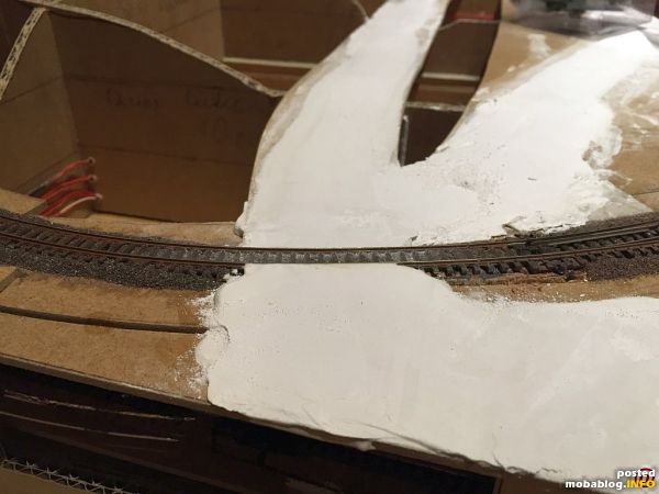 Gips aufgebracht und mit einer Schablone aus Kunststoff abgezogen um das typische Profil einer Pflasterstraße zu erhalten