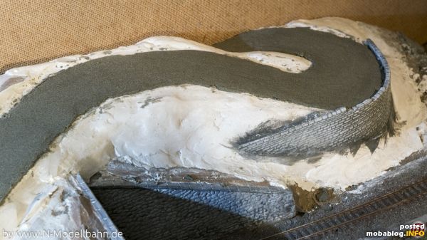 Der "Modellasphalt" wird auf die Trasse aufgebracht und verteilt (ca. 1mm dick). Die Ränder können gut nachgearbeitet werden. Alles sollte ca. 1 Tag trocknen. Danach ist der Belag richtig hart, ...