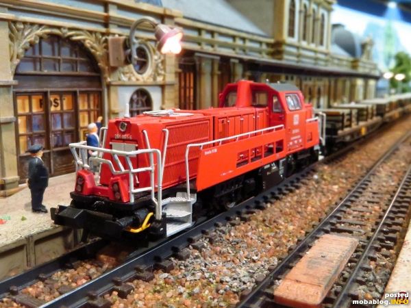 Die 261 (Brawa) passiert mit Stahlbrammenzug den Bahnhof auf Gleis 1.