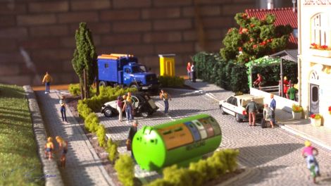 Vom Eingang zum Park sind die Parkboxen der kleinen Straße zu sehen, von der eine für einen Recycling Container genutzt wird.
