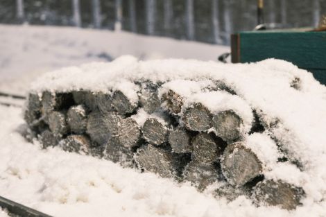 Die fädelt sich hinter dem Holzstapel durch