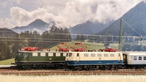 Während die grüne 141 115 mit einem Eilzug in Richtung Innsbruck unterwegs ist, schiebt die blau/beige 141 128 einen Nahverkehrszug nach Garmisch-Partenkirchen. 