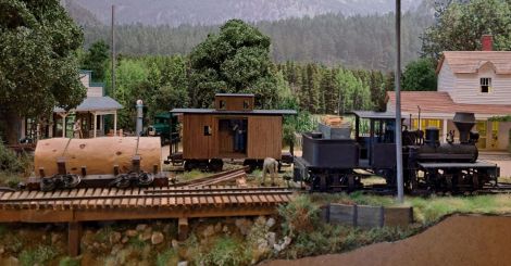 Etwas Eisenbahn am linken Rand des Dioramas. Offensichtlich war der Stamm auf dem Wagen für das Gleis zu schwer. Gezeigt wird hier der Bergeversuch des verunfallten Wagens. Er hängt an ...