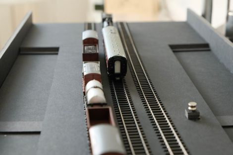 Ein kleiner Metallknopf dient als Bediengriff zum Verschieben des Traversers.