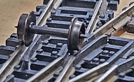 hier sieht man den Radsatz auf der Roco Weiche
durch ung&uuml;nstige Geometrie f&auml;llt der Radsatz in die Herzst&uuml;ckl&uuml;cke 
UND klemmt sich an der Au&szlig;enkante mit der Fl&uuml;gelschiene fest